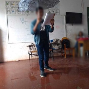 Estudante usa guarda-chuva durante aula por causa de goteiras em escola de Guaratinga